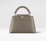 Knockoff Louis Vuitton fake LV Capucines BB LV Bag Etain Metallic Gray M21102. This Capucines BB handbag is crafted from Taurillon leather treated with metallic pigments to give the bag an iridescent aspect. In addition to the top handle