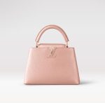 Contrefaçon Louis Vuitton LV Capucines BB LV Bag Pearly Pink M21103. Ce charmant sac à main Capucines BB est confectionné en cuir Taurillon rose nacré et doté de ferrures de couleur or rose. Le cuir Taurillon a été spécialement traité avec un pigment métallique pour donner au sac un aspect subtilement brillant. Le sac est doté d'une poignée supérieure et d'une chaîne amovible.