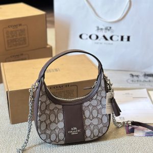 È arrivata la carineria! L'ultima borsa a tracolla Carmen di Coach, a mezzaluna sotto il braccio